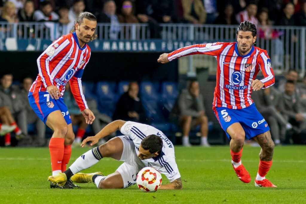 Griezmann y De Paul disputan el balón ante el centrocampista del Marbella, Luis Acosta.