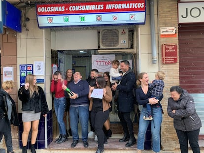 La lotera y su familia celebran el haber vendido el tercer premio de la lotería de El Niño ante su negocio La Estrella.