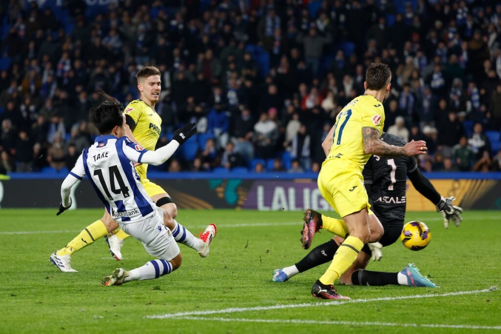 El centrocampista japonés de la Real Sociedad, Takefusa Kubo (i), remata ante el guardameta brasileño del Villarreal, Luiz Júnior, este lunes.