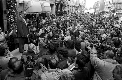 Miguel Saravia, uno de los supervivientes de la matanza, subido a una plataforma, recibe los aplausos de cientos de madrileños ante el número 55 de la calle de Atocha de Madrid, con motivo del 20 aniversario del asesinato de los abogados laboralistas.
