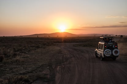 Un grupo de turistas montados sobre un todoterreno de una compañía de safaris contempla una puesta de sol en el parque nacional del Serengeti, Tanzania el 14 de septiembre de 2024