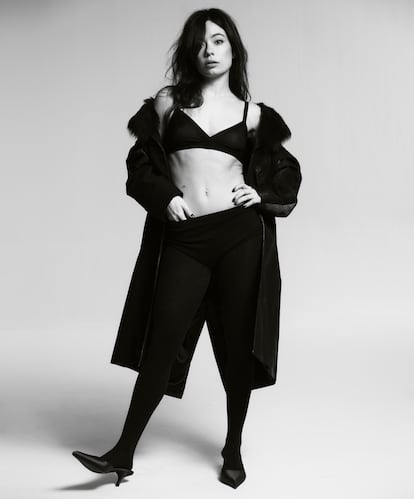 Anna Castillo saltó a la fama en 2013 con la obra de teatro 'La llamada', de Los Javis. “Me gusta que me sigan vinculando a ese proyecto”, reconoce. En esta fotografía, lleva abrigo efecto trampantojo, culote de lana, medias de cachemir, sujetador y 'pumps' de satén, todo de Prada.