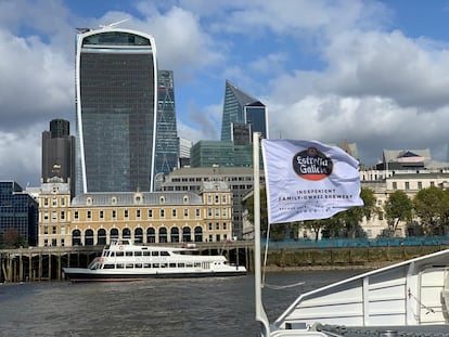 Una embarcación con la bandera de Estrella Galicia atraviesa el río Tamesis, en Londres.