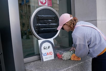Una persona deja flores, junto a un cartel de USAID en la sede de la agencia en Washington, e 7 de febrero.