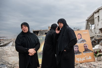 Varias mujeres ante un cartel de milicianos de Hezbolá fallecidos, en El Jiam, a finales de enero.
