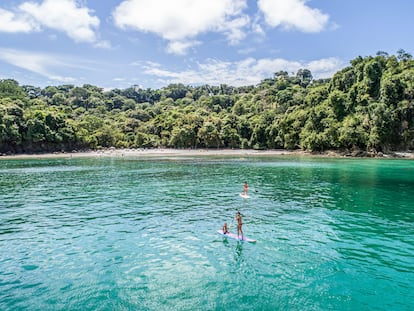 Una familia haciendo paddle surf en Manuel Antonio, Costa Rica.