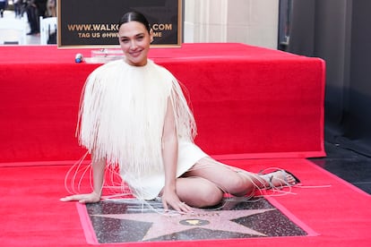 Gal Gadot se sienta sobre su estrella en el Paseo de la Fama de Hollywood.