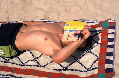 Un joven lee en una playa de Ibiza en 2004. Y lee, precisamente, 'La playa', de Alex Garland.