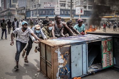 Los manifestantes corean consignas mientras utilizan el mobiliario urbano como barricadas para enfrentarse a los agentes de la policía de Kenia durante una manifestación antigubernamental en el centro de Nairobi, el 2 de julio de 2024.
