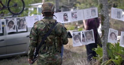 Un militar observa las fotos de los niños perdidos de Armero durante un conmemoración de la tragedia. Fotograma del documental 'Hija del Volcán', cedido por Mayéutica Producciones y Surtsey Films.
