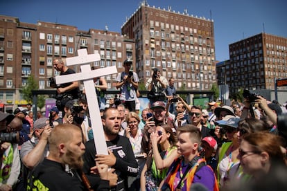 Un grupo de personas sostienen una cruz y libros religiosos  entre los participantes a la marcha del Orgullo en Budapest, este sábado. 