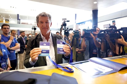  El líder del Partido Popular, Alberto Núñez Feijóo, muestra sus credenciales a su llegada al congreso.