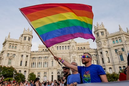 Un manifestante sujeta una bandera arcoíris a su paso por la plaza de Cibeles de Madrid. 