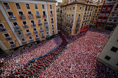 La banda de música municipal se abre paso entre la multitud durante la celebración del chupinazo en la plaza del Ayuntamiento de Pamplona. 