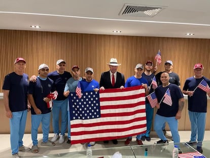 Personas liberadas posando con la bandera de Estados Unidos. 
