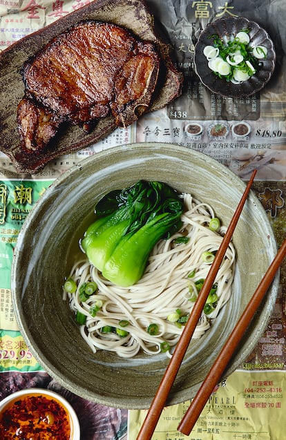 Sopa de fideos de Shanghai con chuleta de cerdo. Cuando los fideos y el pak choy escaldado estén sazonados con sal y aceite de sésamo y regados con el caldo de cerdo, se cortan las chuletas en rodajas y se colocan sobre los noodles con un poco de cebolleta. Es una de las recetas de 'China. Gastronomía', de Kei Lum Chan y Diora Fong Chan (Phaidon).