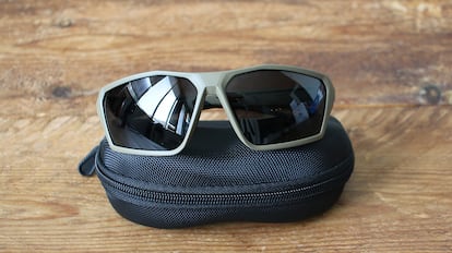 Gafas de sol deportivas sobre una mesa de madera.