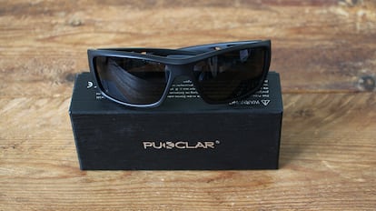 Gafas de sol deportivas sobre una mesa de madera.