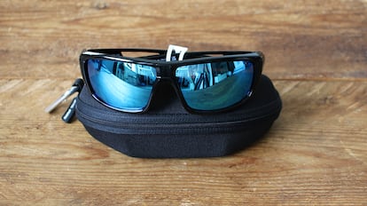 Gafas de sol deportivas sobre una mesa de madera.
