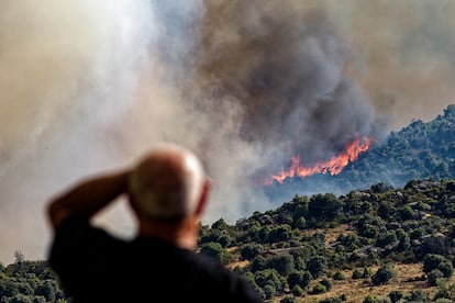 Un hombre contempla un incendio forestal declarado en el término municipal de Navaluenga (Ávila), este viernes. 