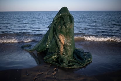 Alessandra García en bañador verde y unas redes rodeándole el cuerpo, en la playa Guadalmar, durante uno de sus ensayos.