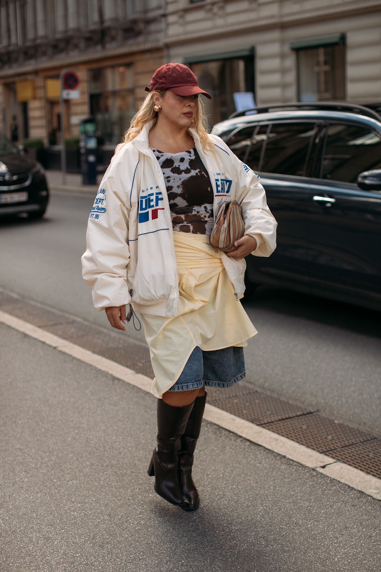 Image may contain Clothing Hat Person Teen Accessories Bag Handbag Footwear Shoe Pedestrian Coat and Car
