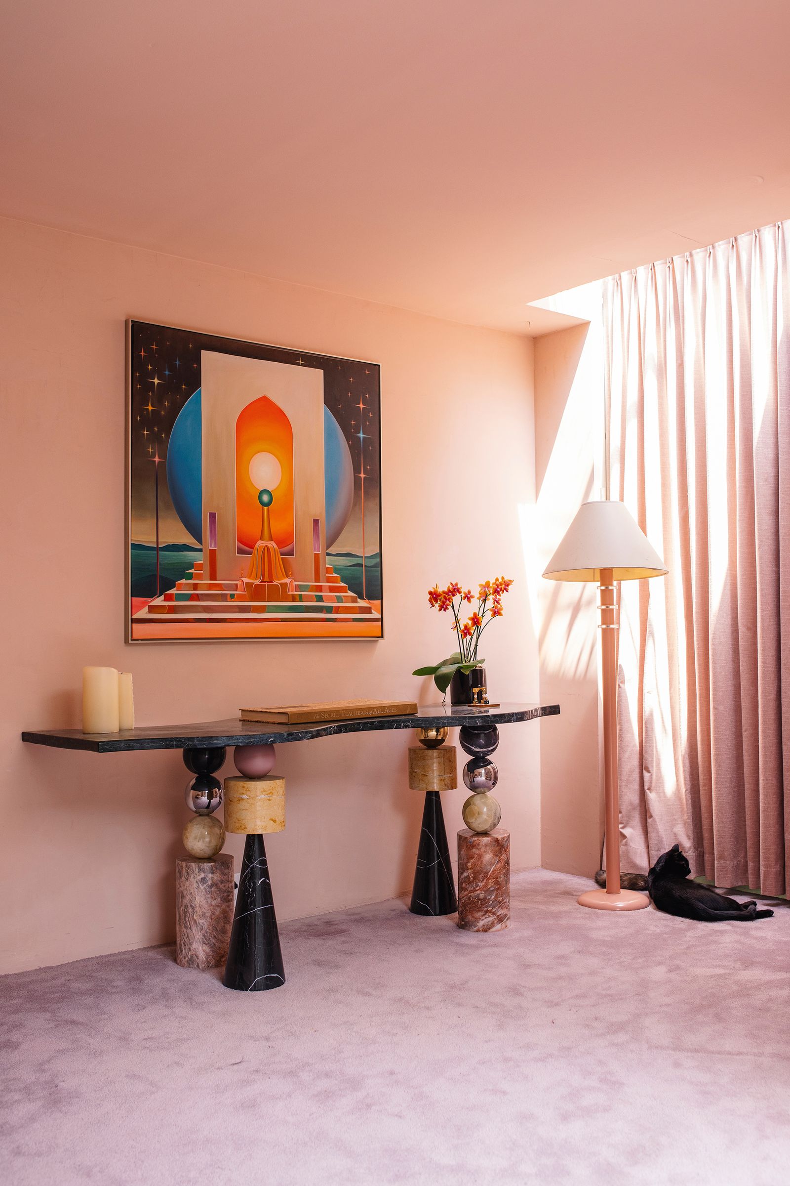 La pintura al óleo ‘Orange Flame debajo escritorio de mrmol y ónix ‘Wavy Desk y lmpara adquirida en un mercadillo.