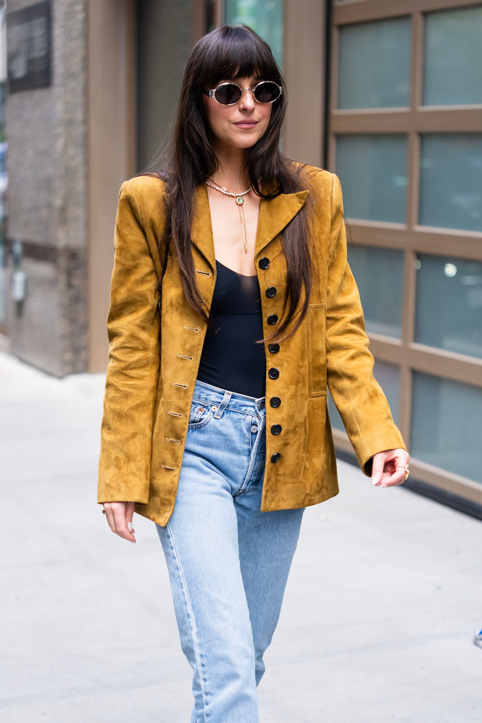 Image may contain Dakota Johnson Blazer Clothing Coat Jacket Pants Jeans Person Teen Accessories and Glasses