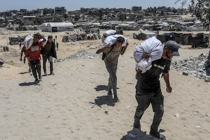 Un grupo de palestinos carga sacos de harina tras una distribución de ayuda humanitaria en Rafah, al sur de la Franja de Gaza, el 31 de julio de 2025.