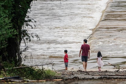 Dos niños y un adulto observan cómo el río Guadalupe en Kerrville, Texas, el 5 de julio de 2025.