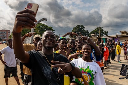 El 'influencer' Kevin Junior Koffee, alias Goodofwar, hace un selfi con chicos del barrio.