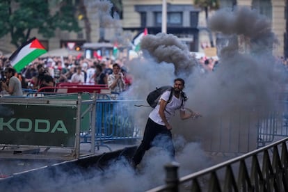 Un manifestante lanza un bote de humo durante la protesta propalestina en Madrid.