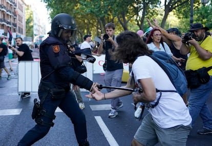 Un agente antidisturbios se enfrenta a un manifestante en Madrid, este domingo.