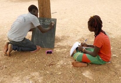 Dos adolescentes estudian por la radio, en Burkina Fasso, como alternativa cuando las clases presenciales no son posibles