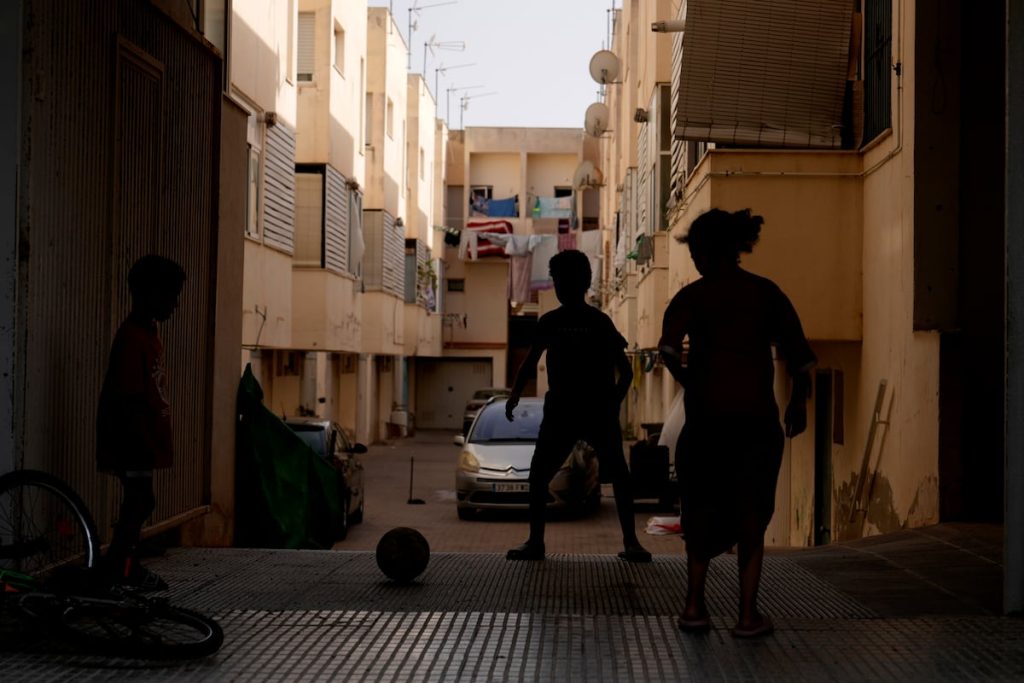 Unos niños de padres magrebíes juegan en el portal de su casa en Torre Pacheco (Murcia) en julio.