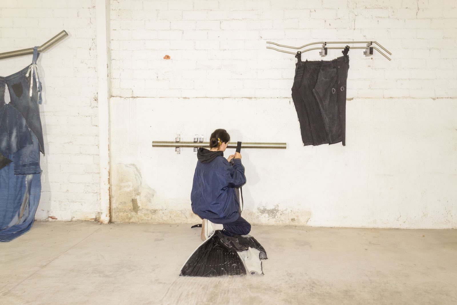 La artista manipulando sus piezas de denim.