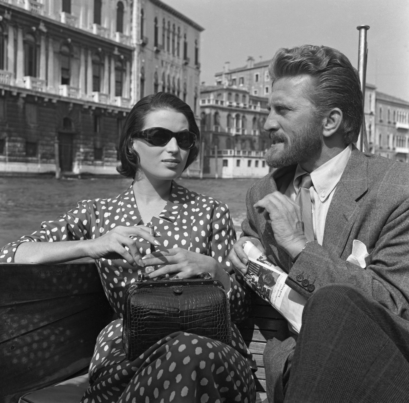 Image may contain Kirk Douglas Silvana Mangano Accessories Sunglasses Bag Handbag Adult Person Body Part and Finger