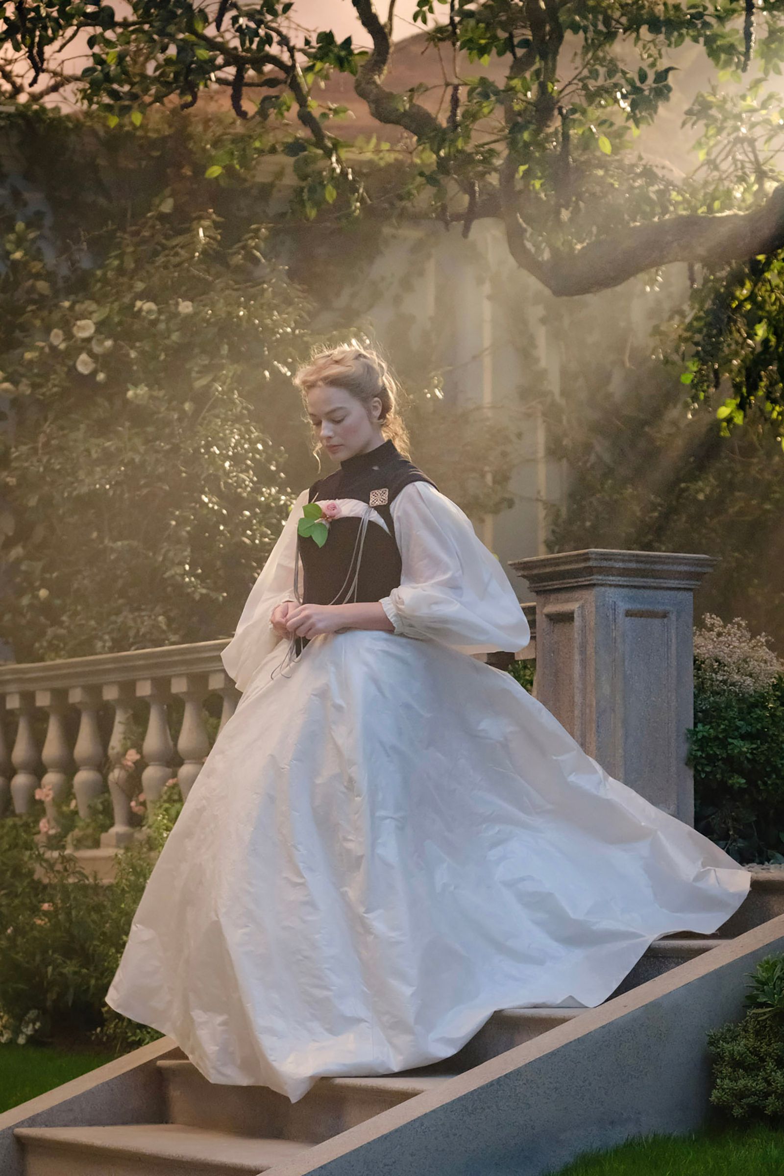 Image may contain Margot Robbie Clothing Dress Person Formal Wear Fashion Gown Wedding Wedding Gown and Sitting