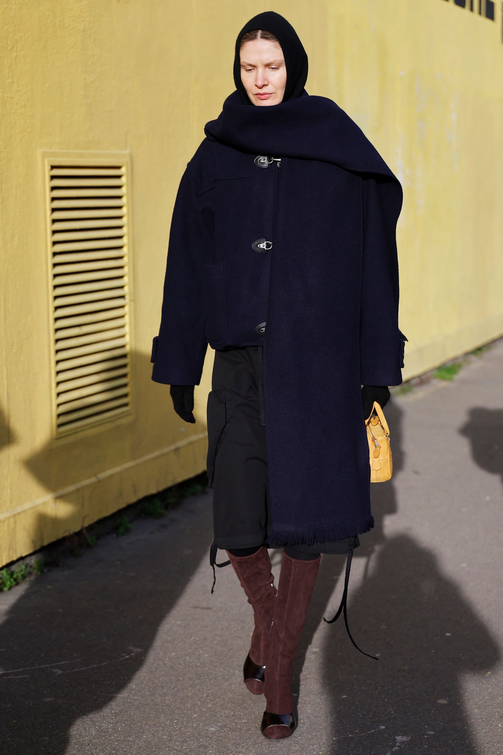 PARIS FRANCE  JANUARY 24 A guest wears blue coat with scarf attached black shorts brown suede boots black gloves yellow...
