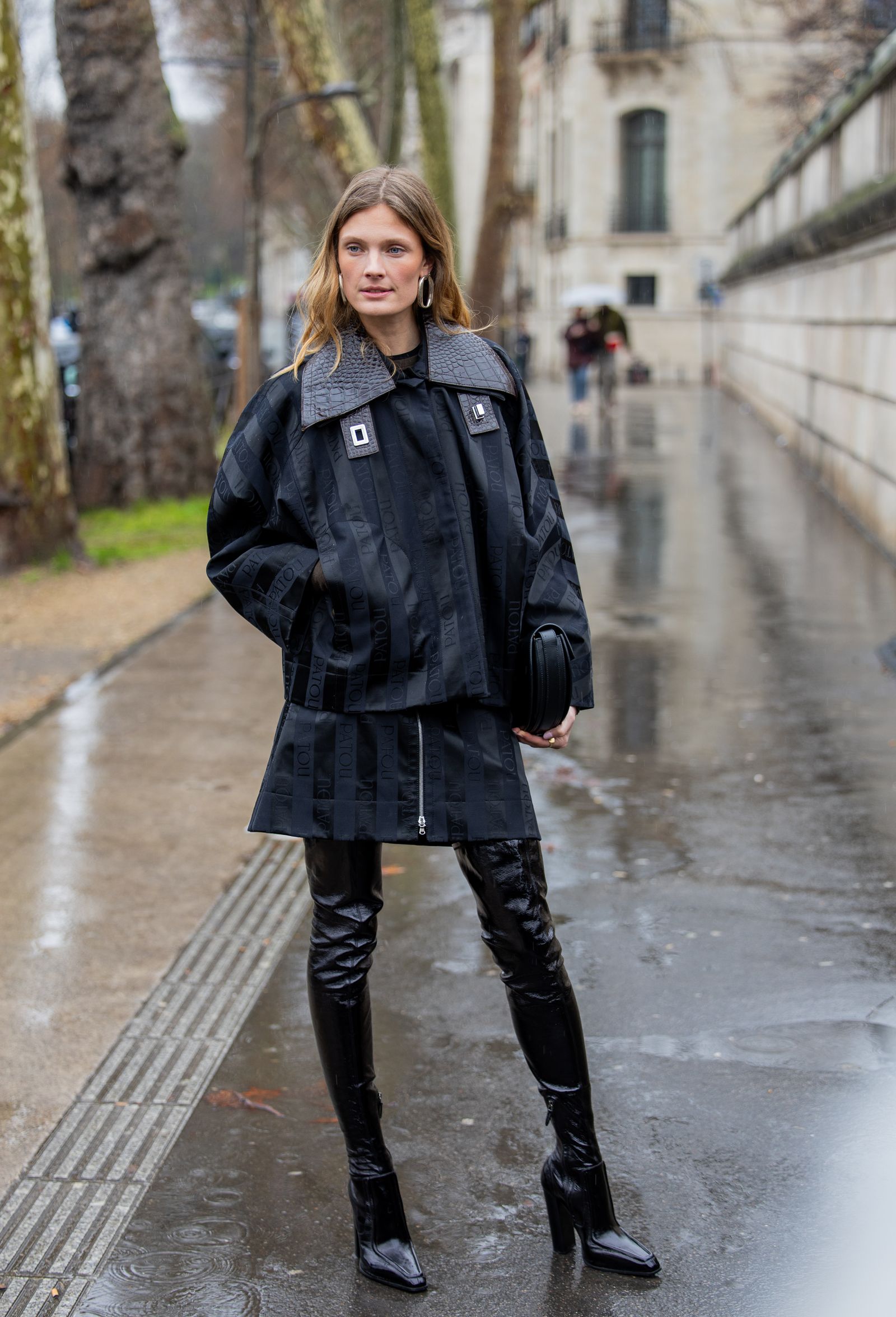PARIS FRANCE  JANUARY 25 A guest wears oversized jacket black bag over knees boots outside Patou during the Menswear...