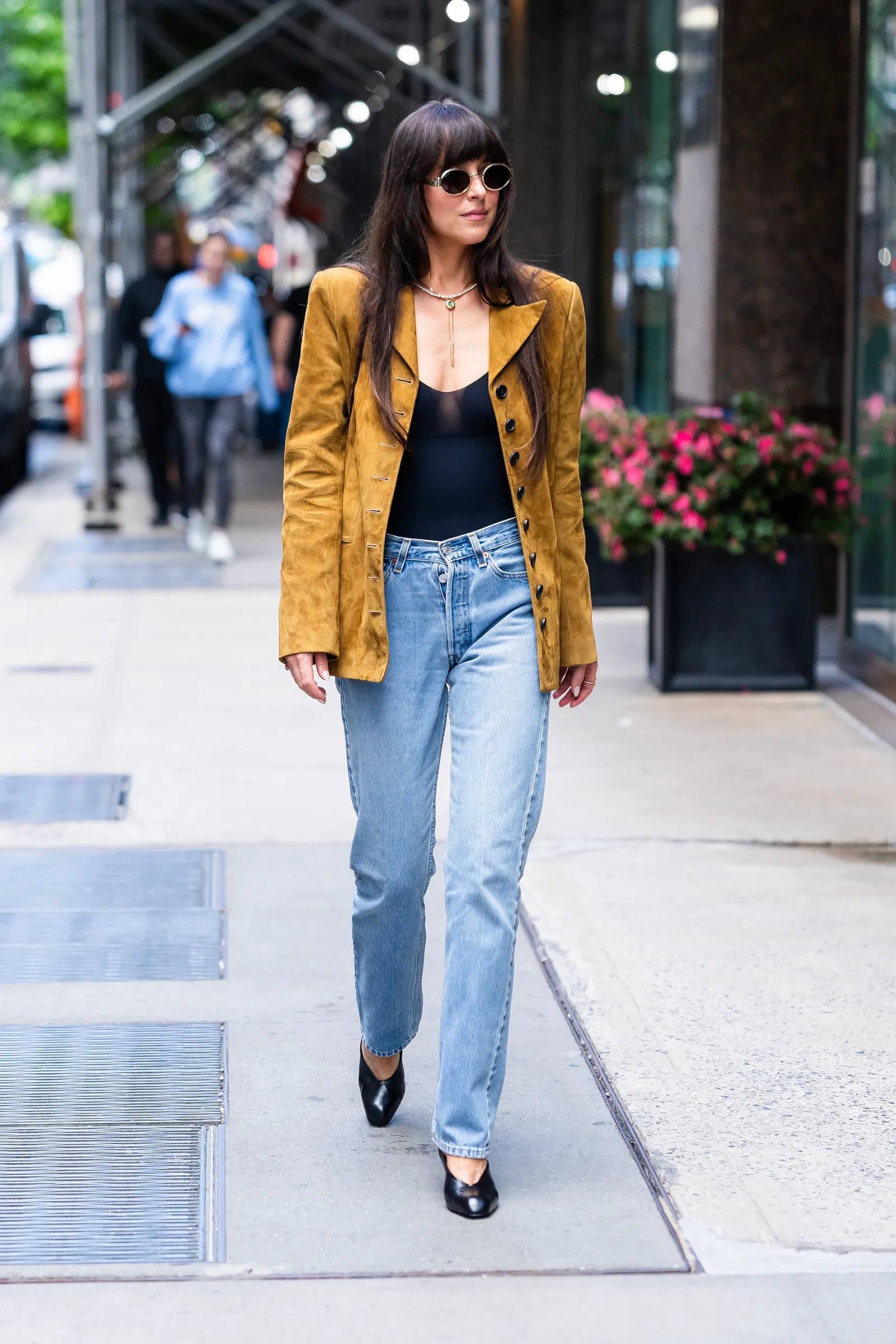 Image may contain Dakota Johnson Clothing Pants Jeans Blazer Coat Jacket and Person
