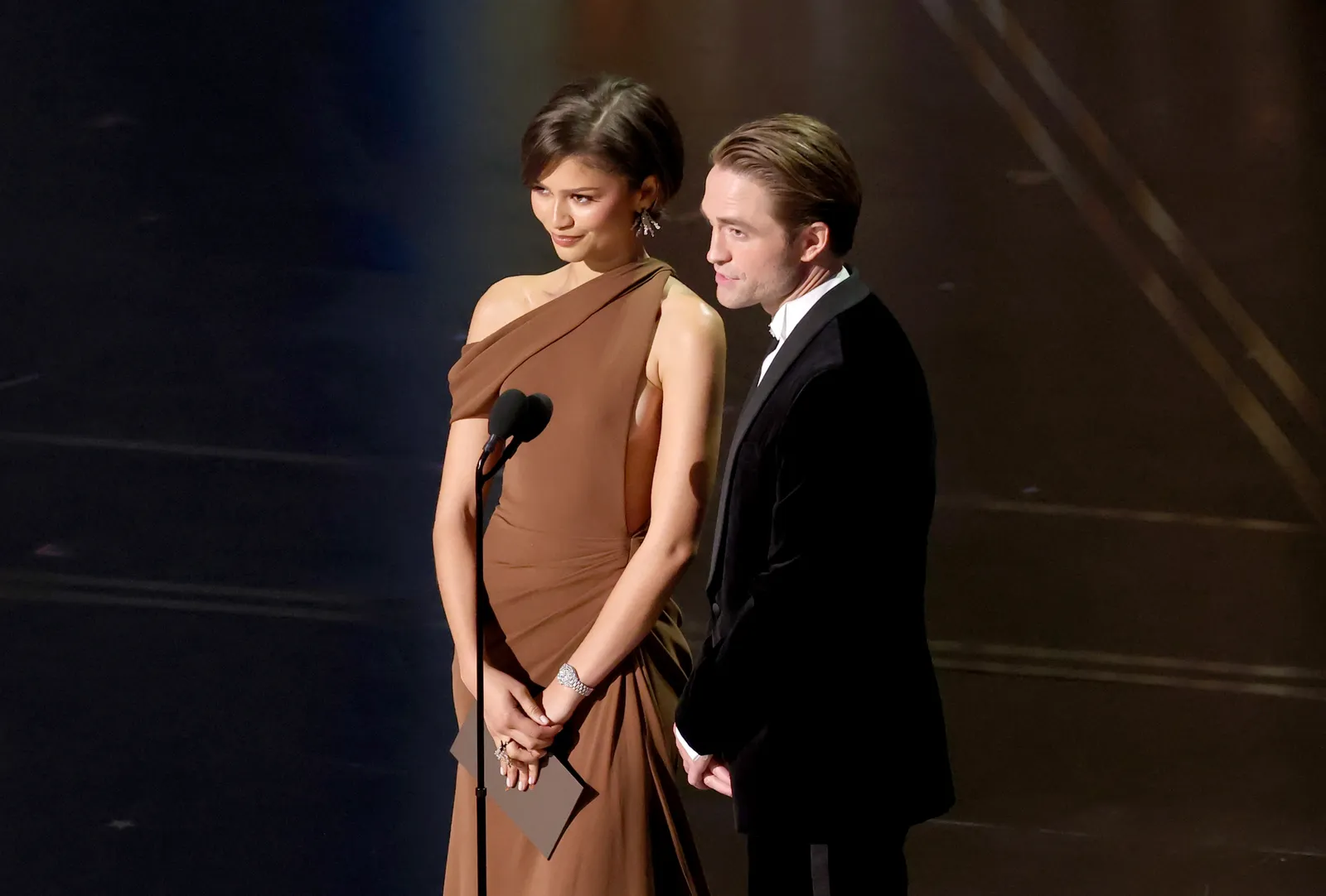 Image may contain Robert Pattinson Zendaya Adult Person Body Part Hand Formal Wear Clothing Dress and Head
