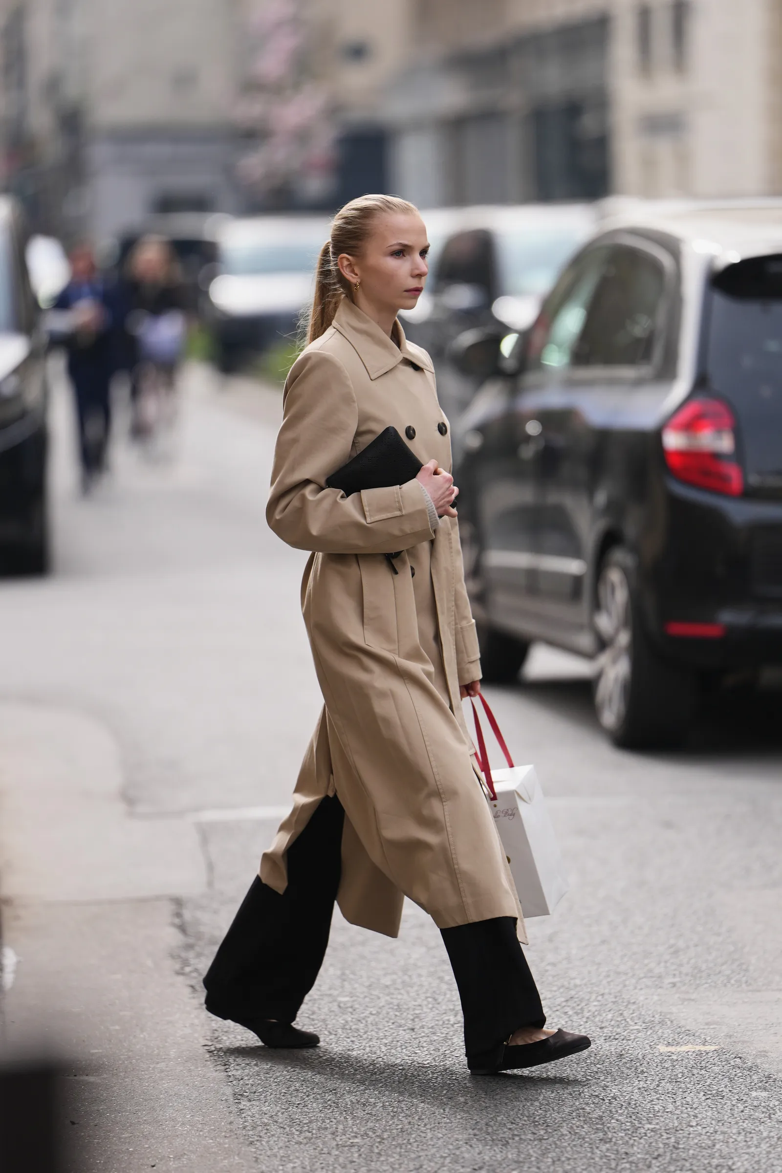 PARIS FRANCE  MARCH 07 A guest wears blonde hair in a ponytail a beige cotton double breasted trench long coat black...
