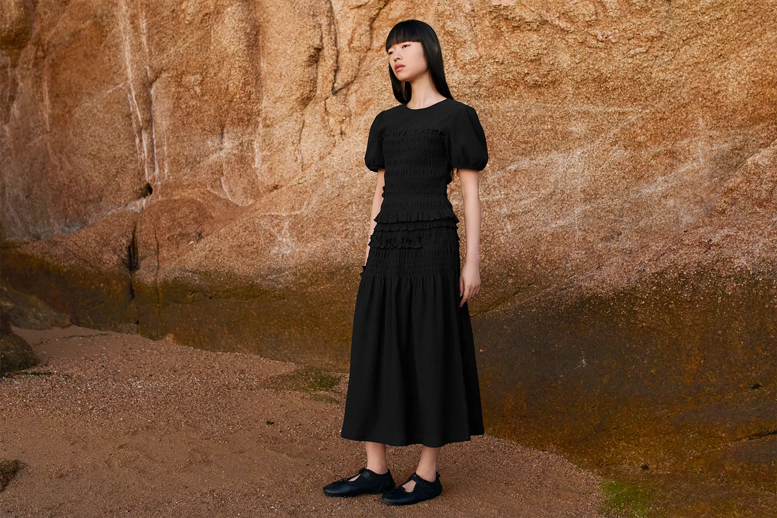 Image may contain Clothing Dress Evening Dress Formal Wear Adult Person Sleeve Standing Face Head and Footwear