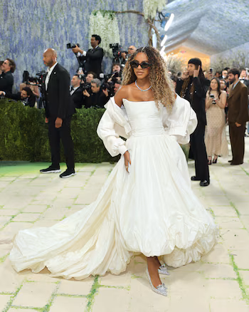 Blue Ivy Carter optó por un vestido largo blanco con falda voluminosa de textura satinada y escote recto, acompañado de una chaqueta a juego con solapas estructuradas