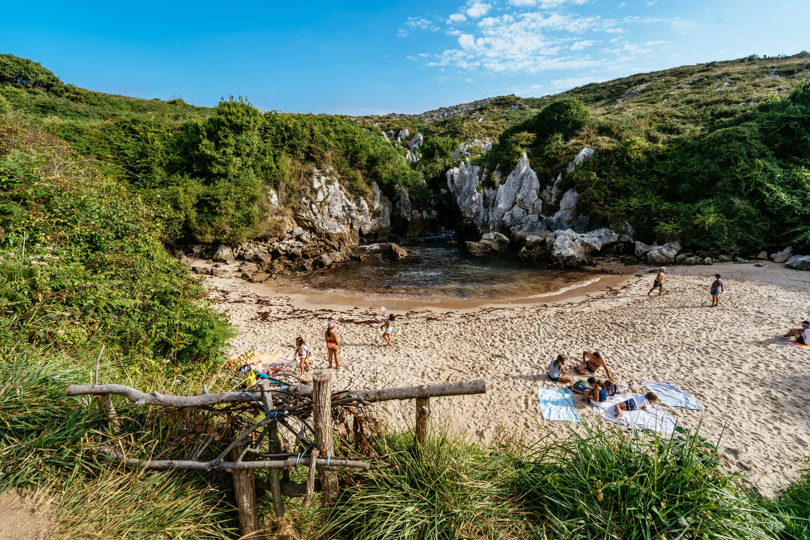 LLANES ASTURIAS SPAIN  20190824 People having sun in Gulpiyuri beach  a flooded sinkhole with an inland beach.